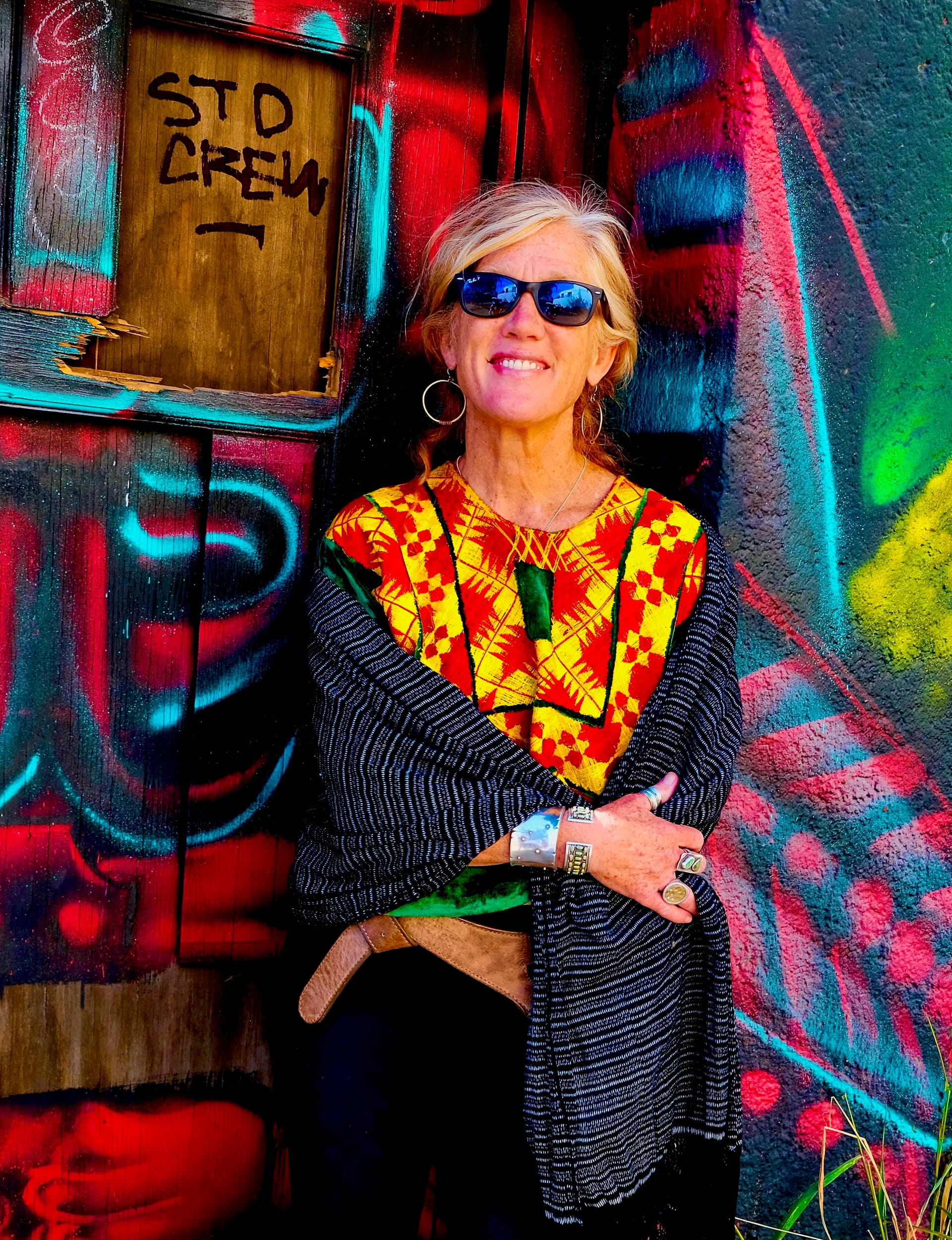 Catherine McLaughlin-Hills against a graffitied wall, in an embroidered Oaxacan huipil
